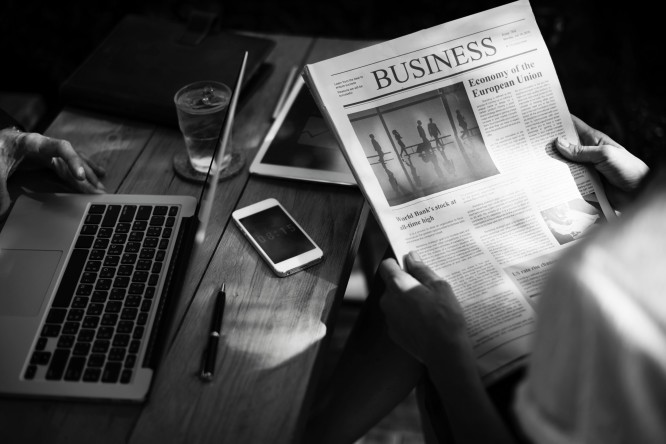 επιχειρηματίας διαβάζει νέα στην εφημερίδα