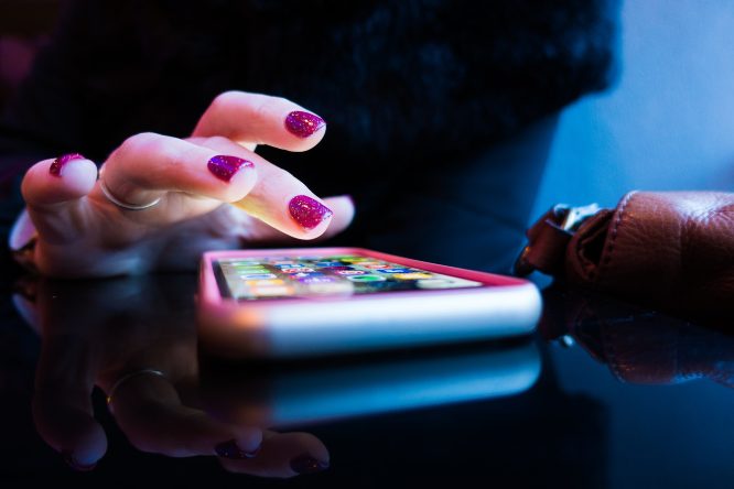 woman-uses-phone-purple-nails