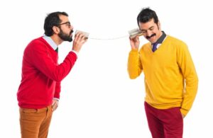 Twin brothers talking through a tin phone